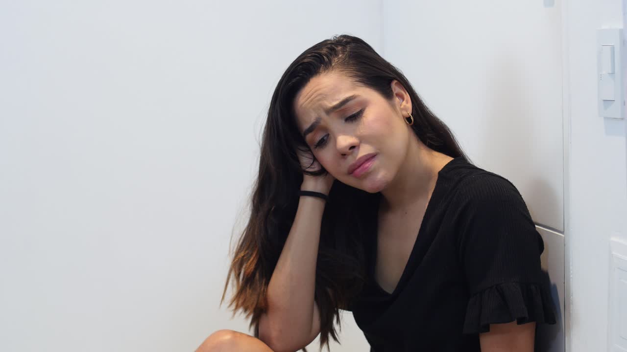 una mujer deprimida con el corazón roto tendida en el suelo.