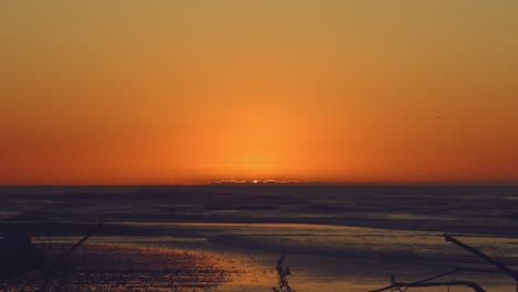 La-Magnífica-Puesta-De-Sol-Crea-Colores-Naranja-Y-Dorado-Sobre-Un-Mar-En-Calma---Mar-De-Tasmania,-Costa-Oeste