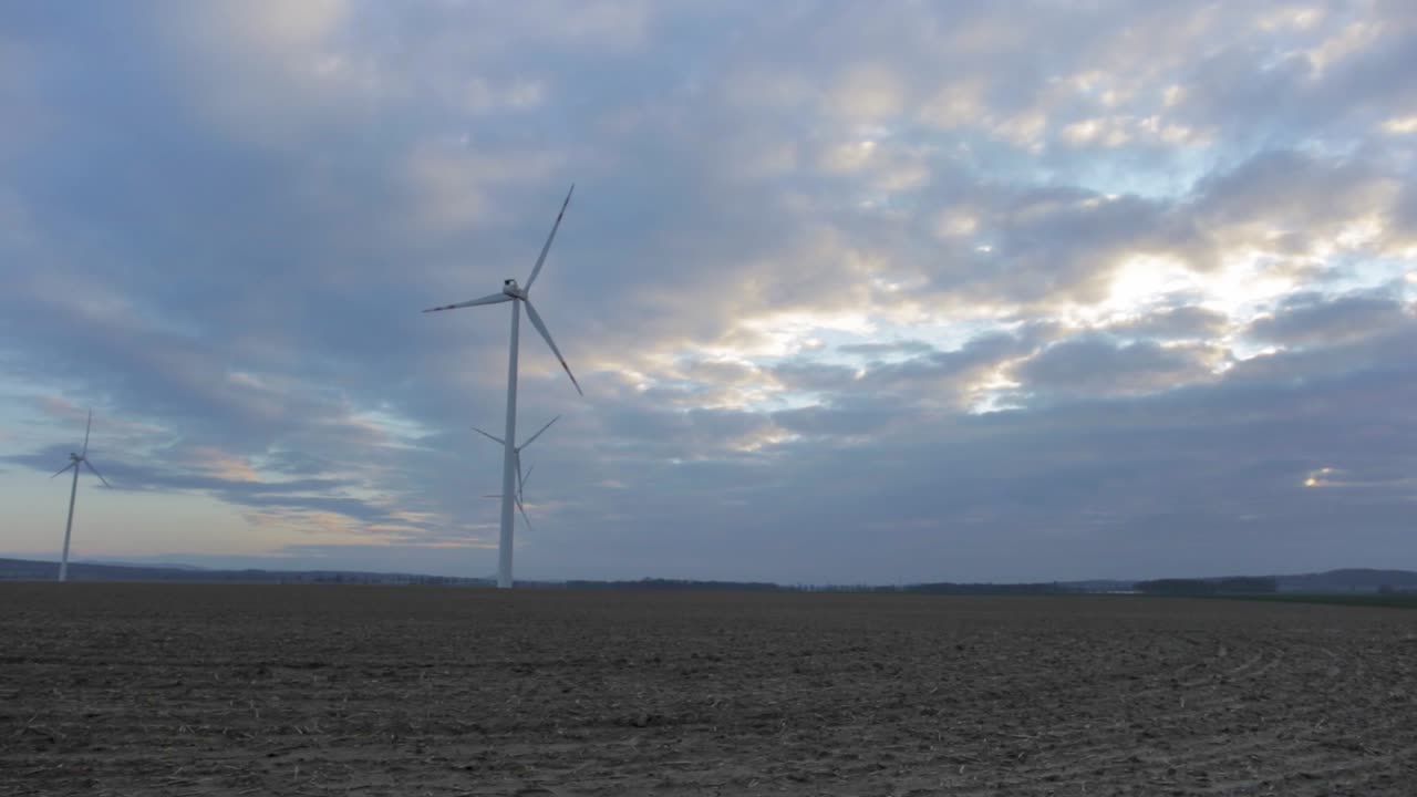 Wind Turbines Spinning In The Vast Field Of Zlotoryja In Poland With Dramatic Sky In The Background - trucking shot