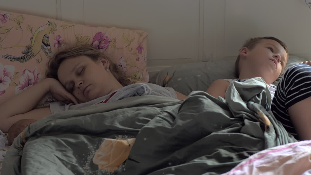 madre durmiente bebé y hijo mayor en la cama