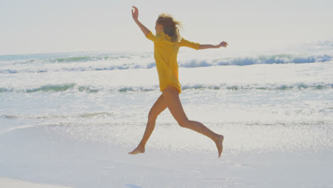 side view of young caucasian woman running on the beach 4k