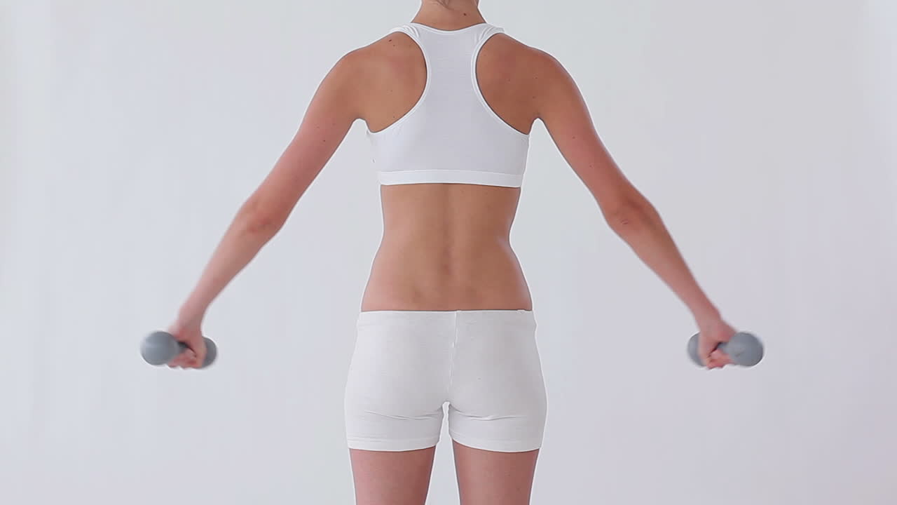 Rear view of a woman using dumbbells