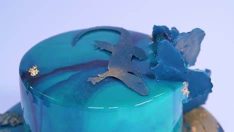 impresionante pastel esmaltado de turquesa con decoración de lagarto y hoja de oro