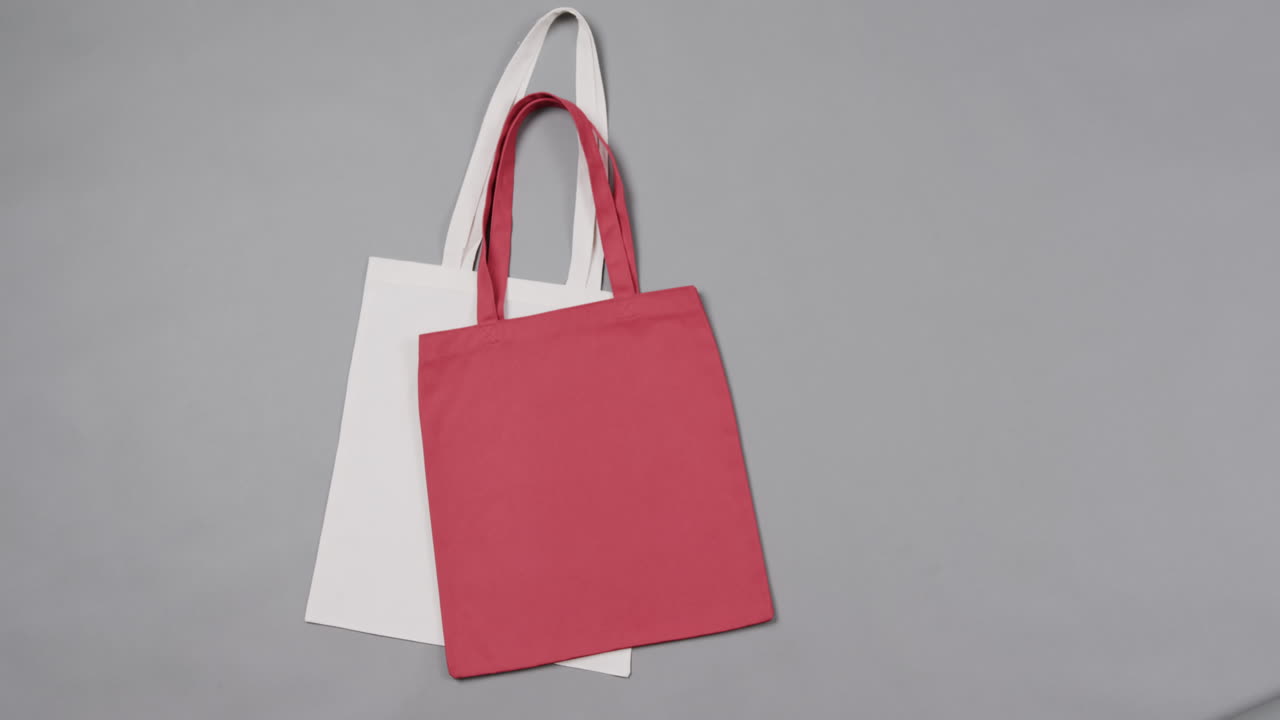 primer plano de bolsas blancas y rojas sobre un fondo gris, con espacio de copia, cámara lenta