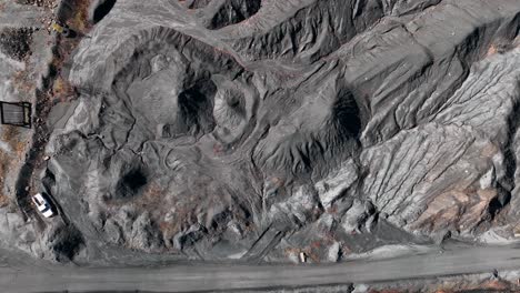 top down aerial of piles of coal at strip mine