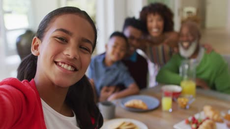 Afroamerikanisches-Mädchen,-Das-Ein-Selfie-Macht,-Während-Es-Mit-Seiner-Familie-Zu-Hause-Frühstückt