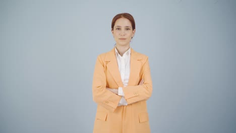 mujer de negocios con los brazos cruzados y riéndose de la cámara.