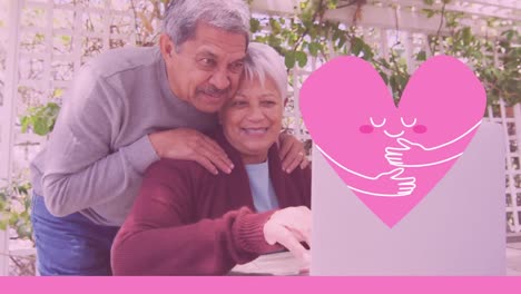 icono del corazón rosa contra una pareja de ancianos afroamericanos que usan una computadora portátil en el jardín