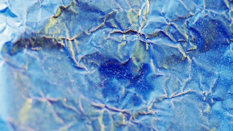 Close-up-of-blue-crumpled-piece-of-paper-in-slow-motion