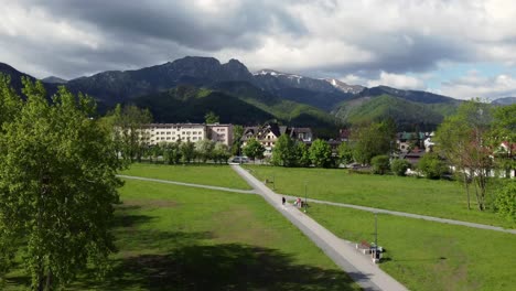 Famous-wooden-Zakopane-sign-near-Polish-Tatry-Mountains,-farmland,-forests,-overcast-sky,-and-legendary-Giewont-peak-near-Zakopane,-Poland,-a-resort-town-with-traditional-Goral-architecture---4k-30fps