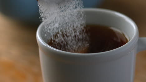 azúcar vertiendo en la taza de té