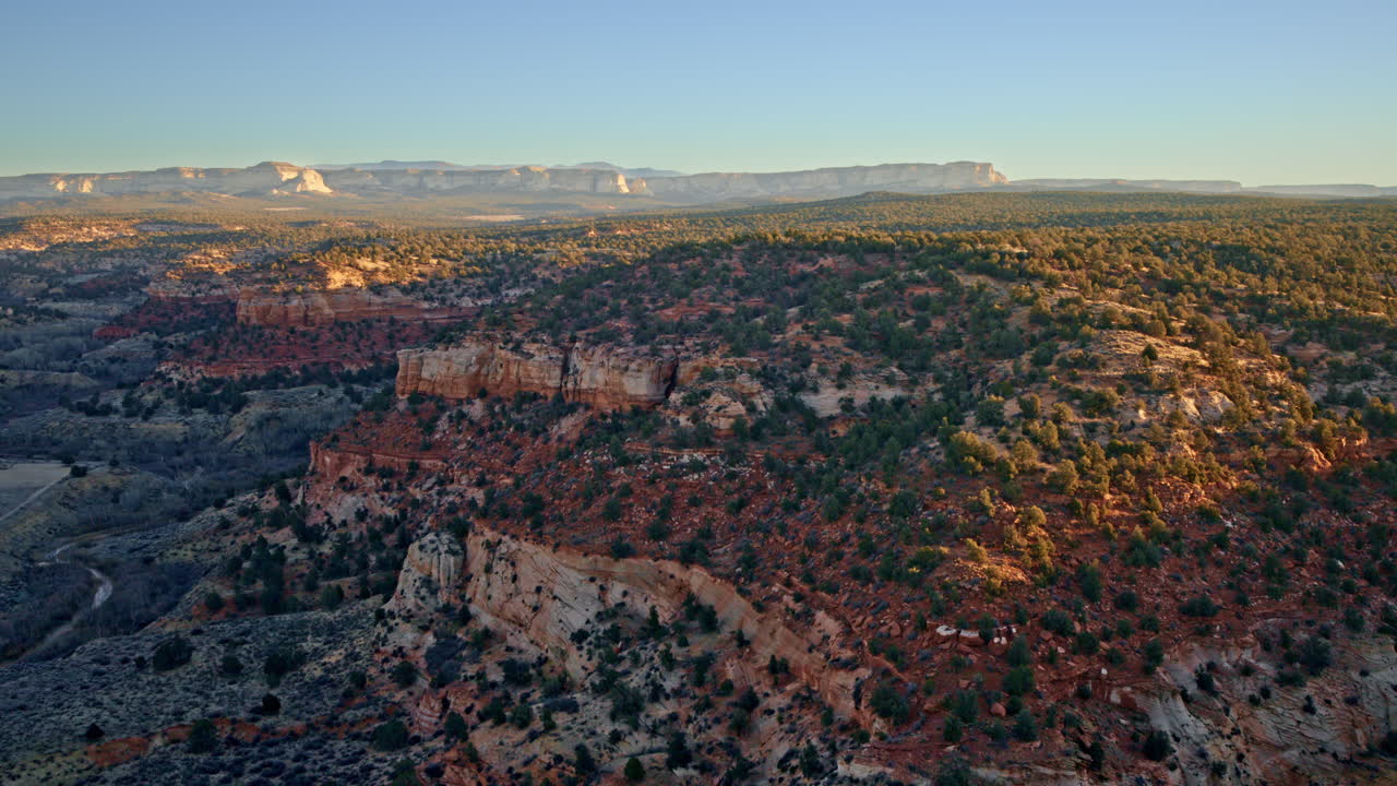 High-altitude drone view over the rugged Canyonlands near Kanab, Utah, at sunrise.