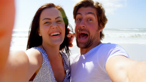 Front-view-of-young-caucasian-couple-having-fun-at-beach-on-a-sunny-day-4k