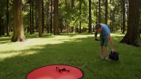 El-Hombre-Vuela-Un-Pequeño-Dron-En-Un-Parque,-Día-Soleado,-Tiro-Estático