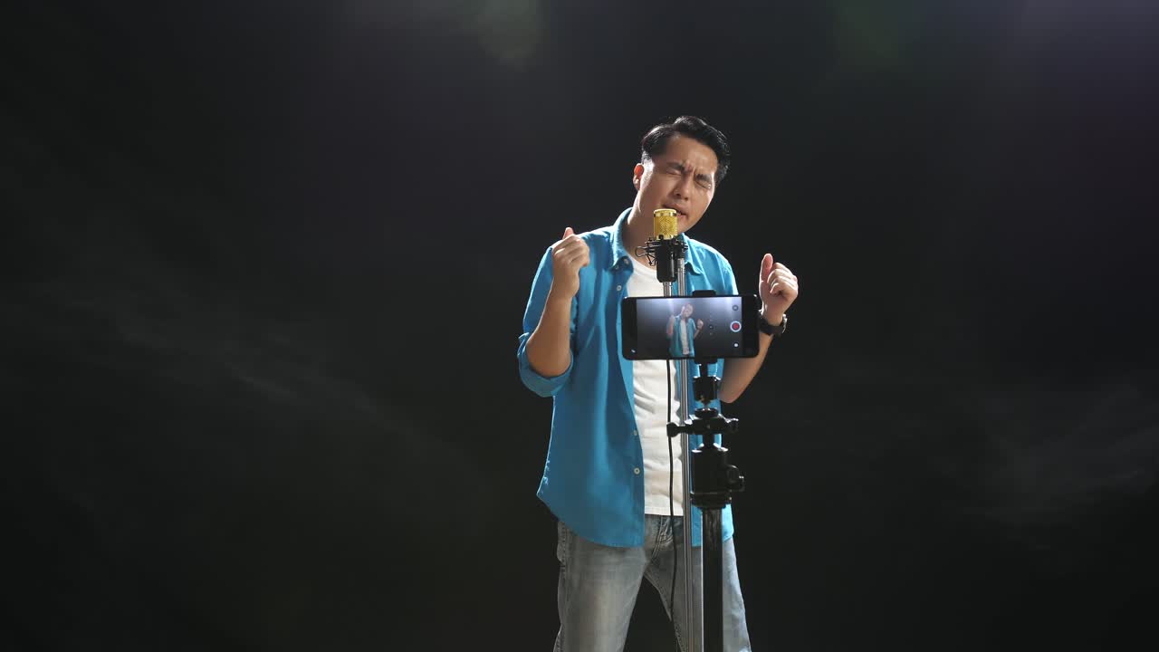 hombre cantando y grabando un video