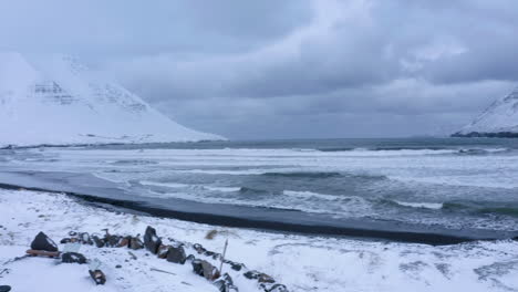 arctic ocean waves hit the coast at olafsfjordur town in north iceland