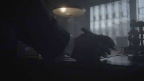 man writing at vintage office desk