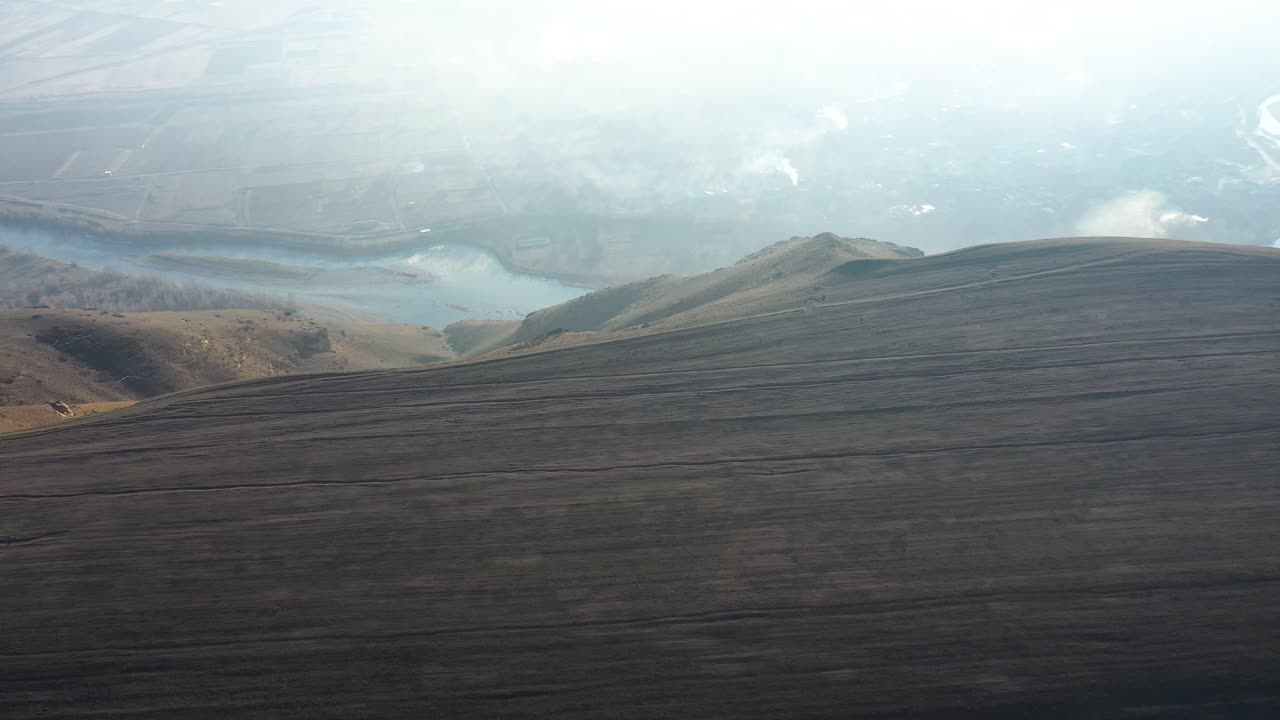 reveladora toma del río mtkvari cerca de uplistsikhe en georgia en una mañana soleada, dron aéreo, inclinado hacia abajo