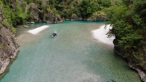 fantastic aerial shot over lake komani and in which a boat can be seen approaching the shore of the lake