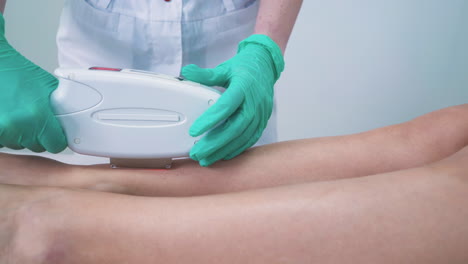 dermatologist in gloves does laser epilation to girl