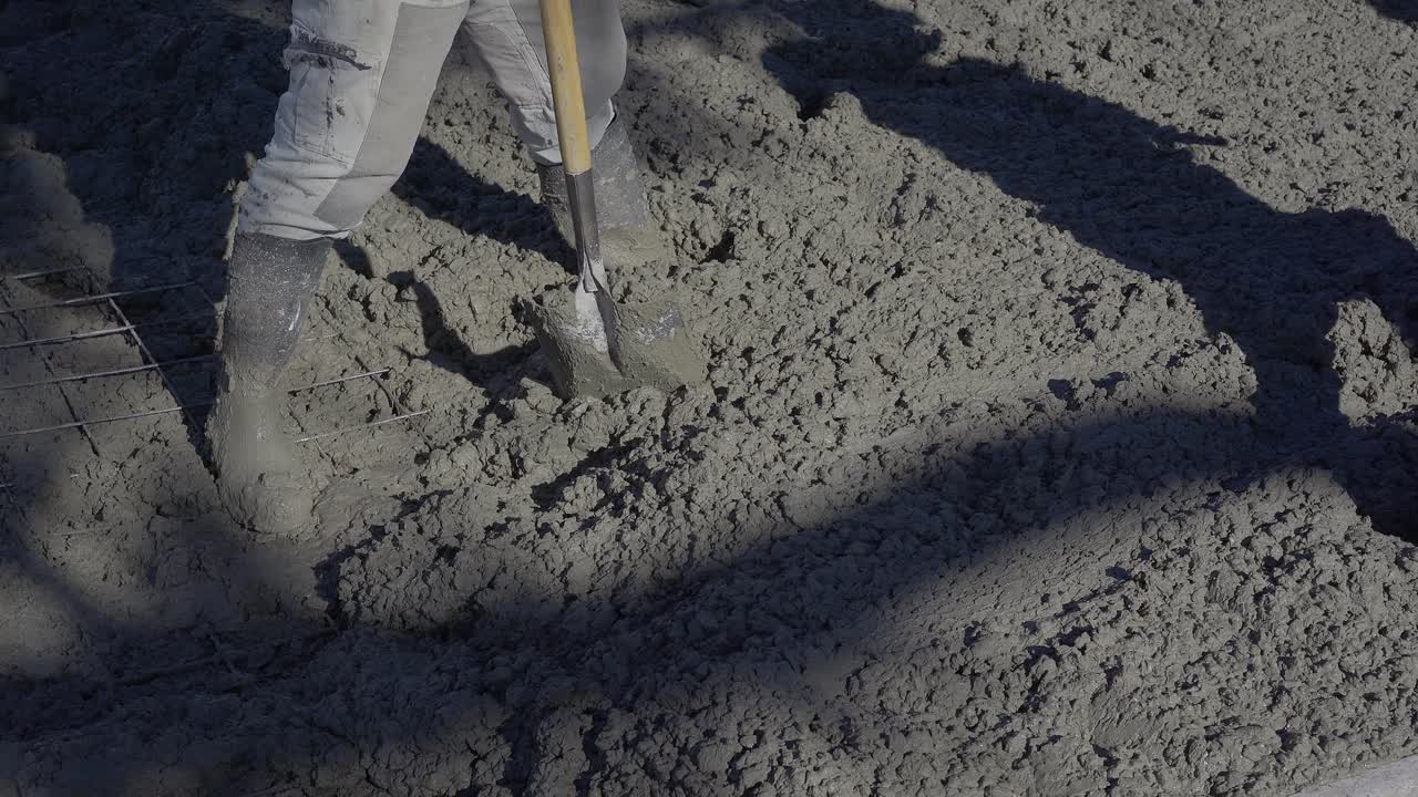 Using shovels, workers lay fresh asphalt on a city street. High angle view.