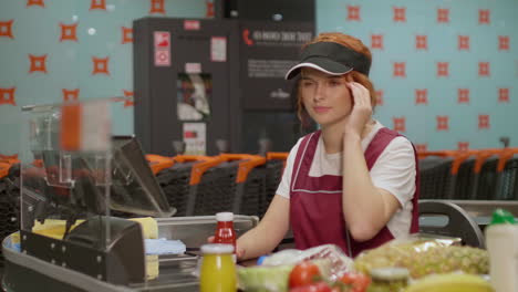 junge verkäuferin, die kopfschmerzen hat, während sie in einem supermarkt arbeitet