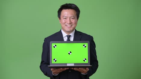 녹색 배경에 성숙한 일본 사업가