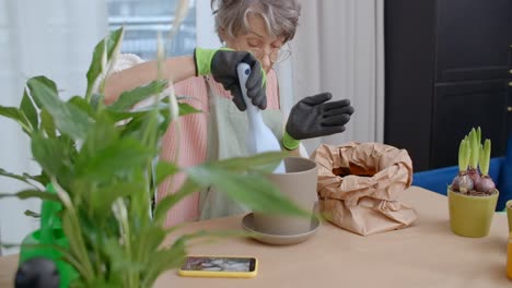 senior woman repotting houseplants