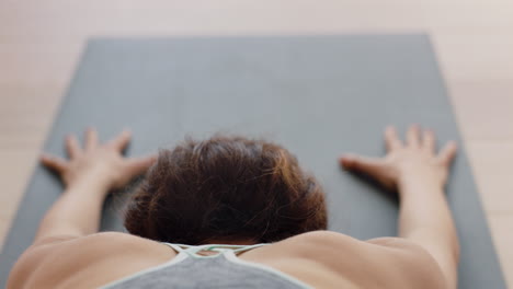cerrar clase de yoga mujer afroamericana practicando pose infantil disfrutando de un estilo de vida saludable ejercitando cuerpo flexible en el gimnasio vista trasera