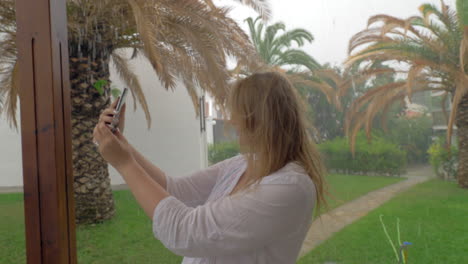 Cheerful-woman-making-summer-selfie-on-rainy-day