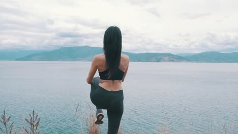 woman doing stretching exercises in front of the sea, preparing to run