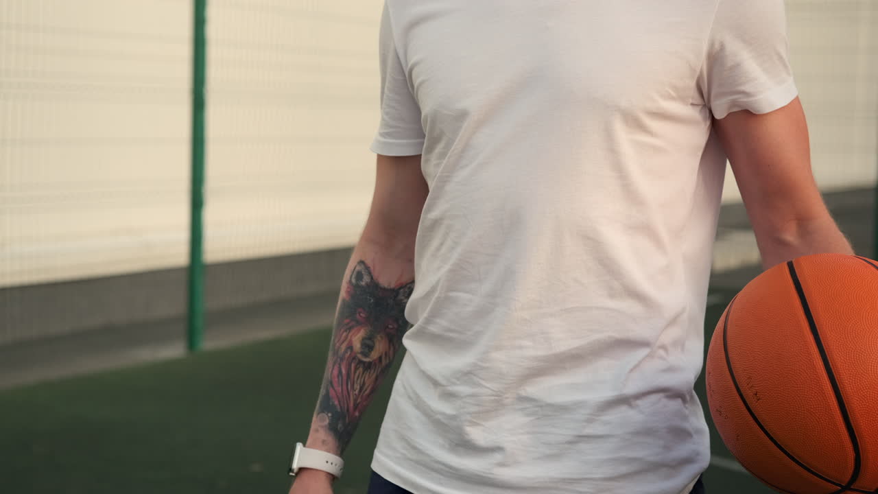 hombre sosteniendo una pelota de baloncesto en una cancha