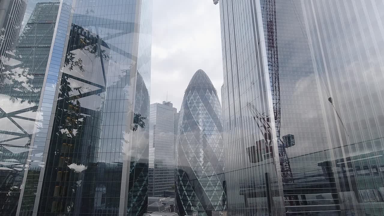 구름 반사와 건설 크레인이 있는 런던 비즈니스 건물의 저속 촬영