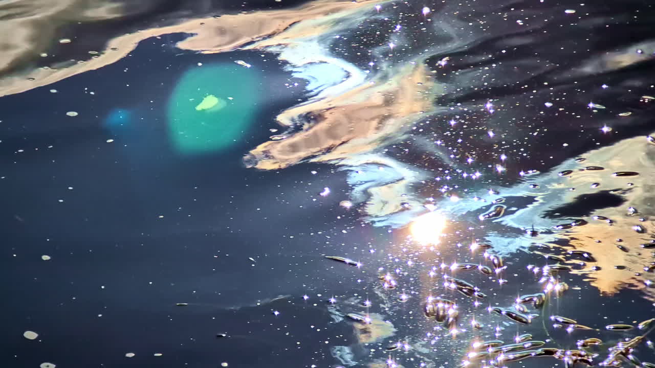 Sunlight reflecting on rippling water surface with floating particles and lens flare