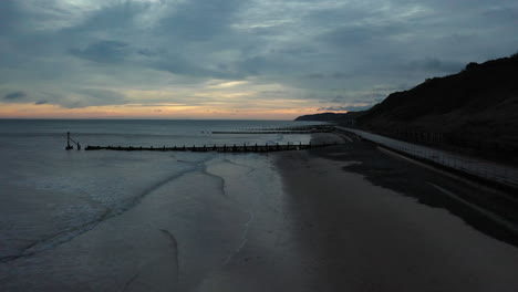 aerial drone flight along overstrained beach at sunrise