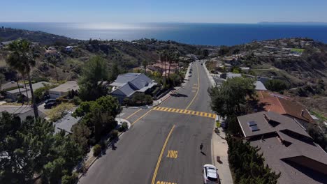 Hombre-Trotando-Cuesta-Abajo-En-Laguna-Beach-Hills,-Con-Vista-Al-Océano-Pacífico