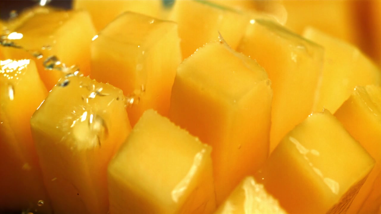 Acqua rinfrescante che schizza su mango succoso a cubetti