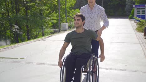 the man drives the disabled teenager in a wheelchair.