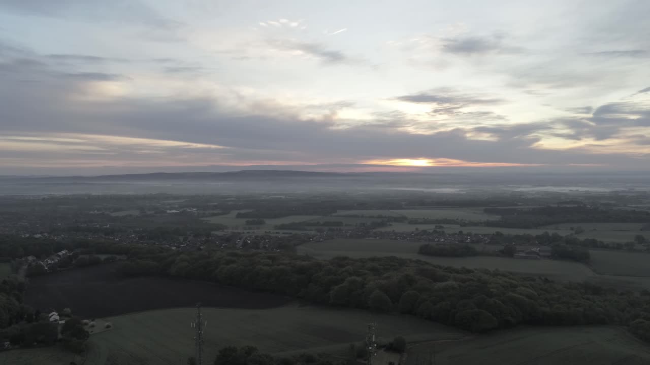 Early sunrise aerial telecom towers on agricultural rural farmland countryside dolly left