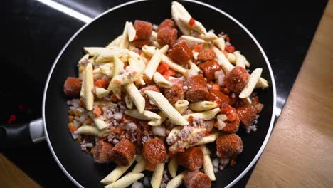 Shot-of-teflon-non-stick-pan-on-the-stove-with-premade-frozen-pasta-with-sauce-in-it