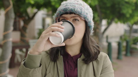 Porträt-Einer-Freundlichen-Hipster-Frau-Mit-Einer-Flippigen-Brille,-Die-Kaffee-Trinkt-Und-Entspannt-In-Der-Stadt-Lächelt-Und-Den-Lebensstil-Genießt