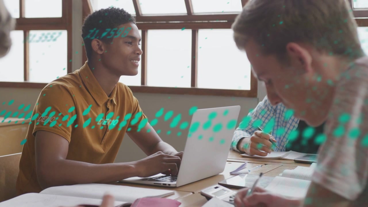 Youth male typing on laptop, leading classmates to study as teal data overlay sweeping across table