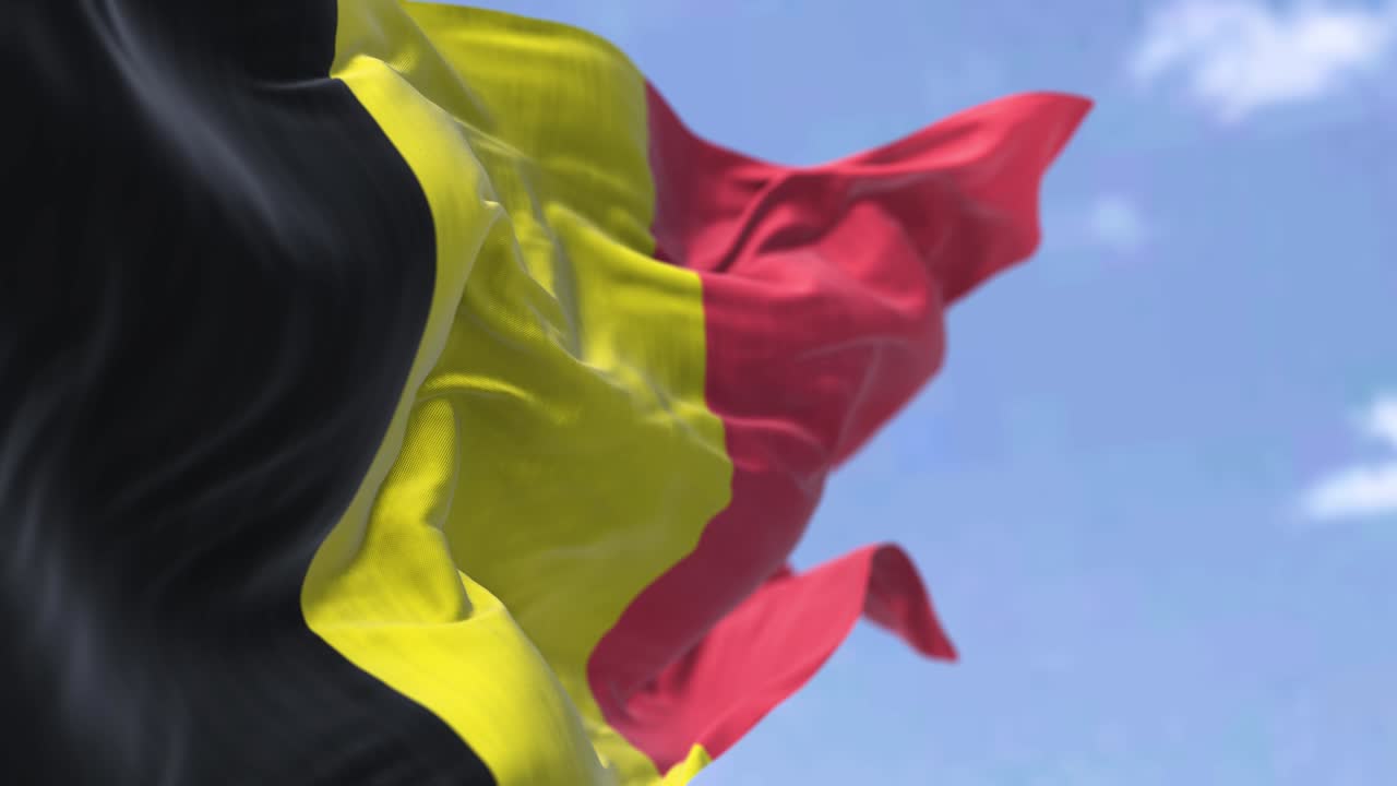 деталь национального флага бельгии, размахивающего ветром в ясный день.