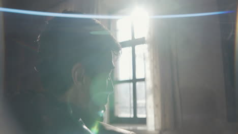 man looking out window in old house