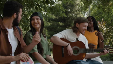 diverse group of friends playing music and socializing outdoors