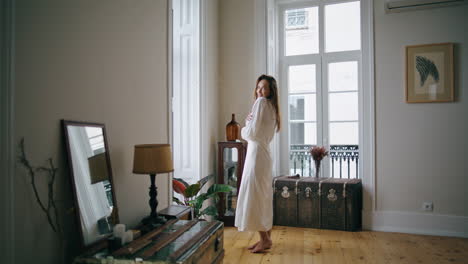 dreaming model watching window cozy interior. tender woman touching hair posing