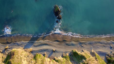 Drohne-Blickt-Auf-Kiesstrand-Und-Kleine-Insel-Mit-Wellen-Waterford,-Irland