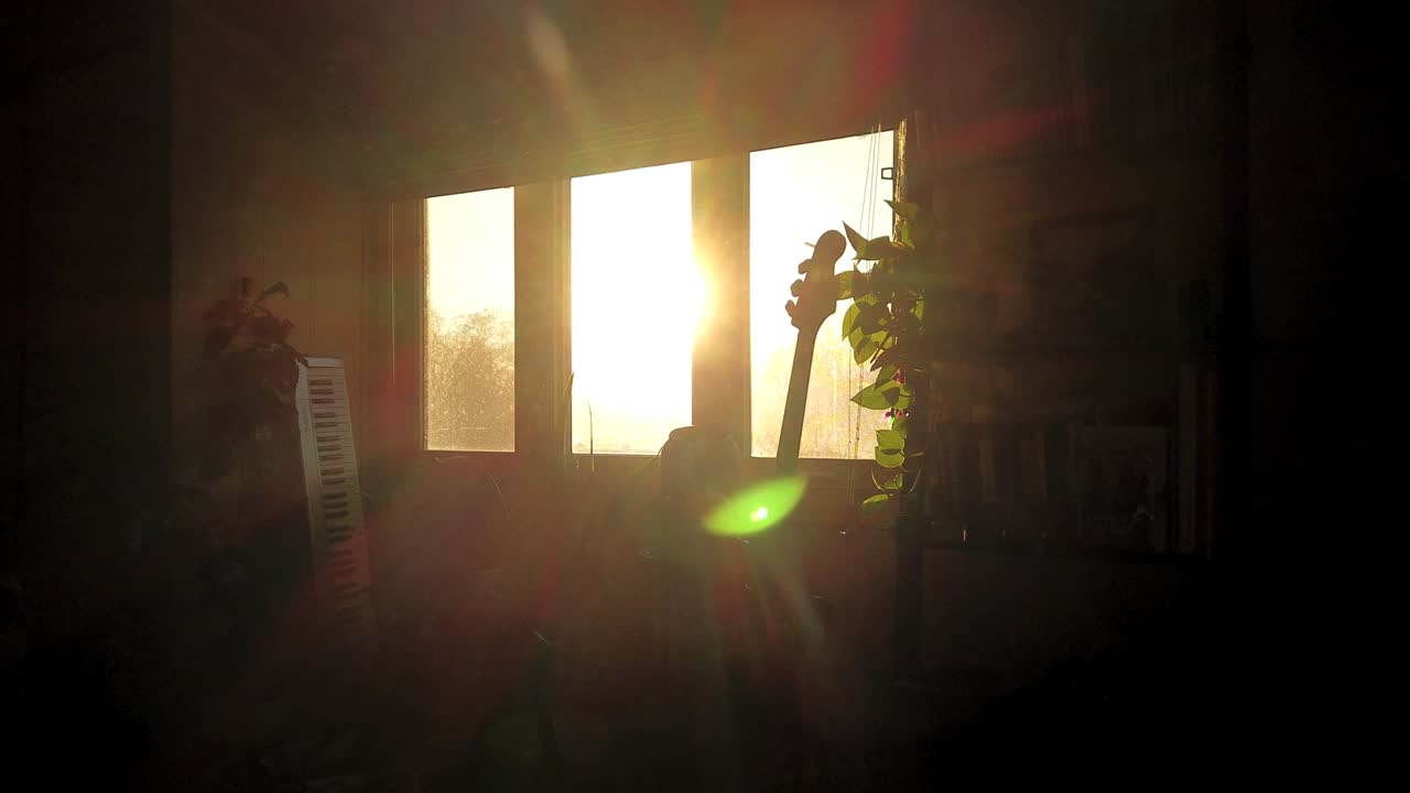 Time-lapse of early morning sunrise outside a living room window with lens refraction