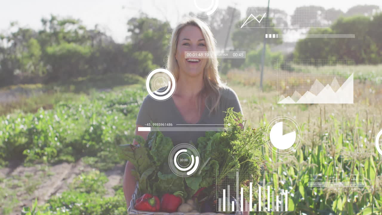 Female farmer holding crate of fresh vegetables in sunny field, showing agricultural data charts