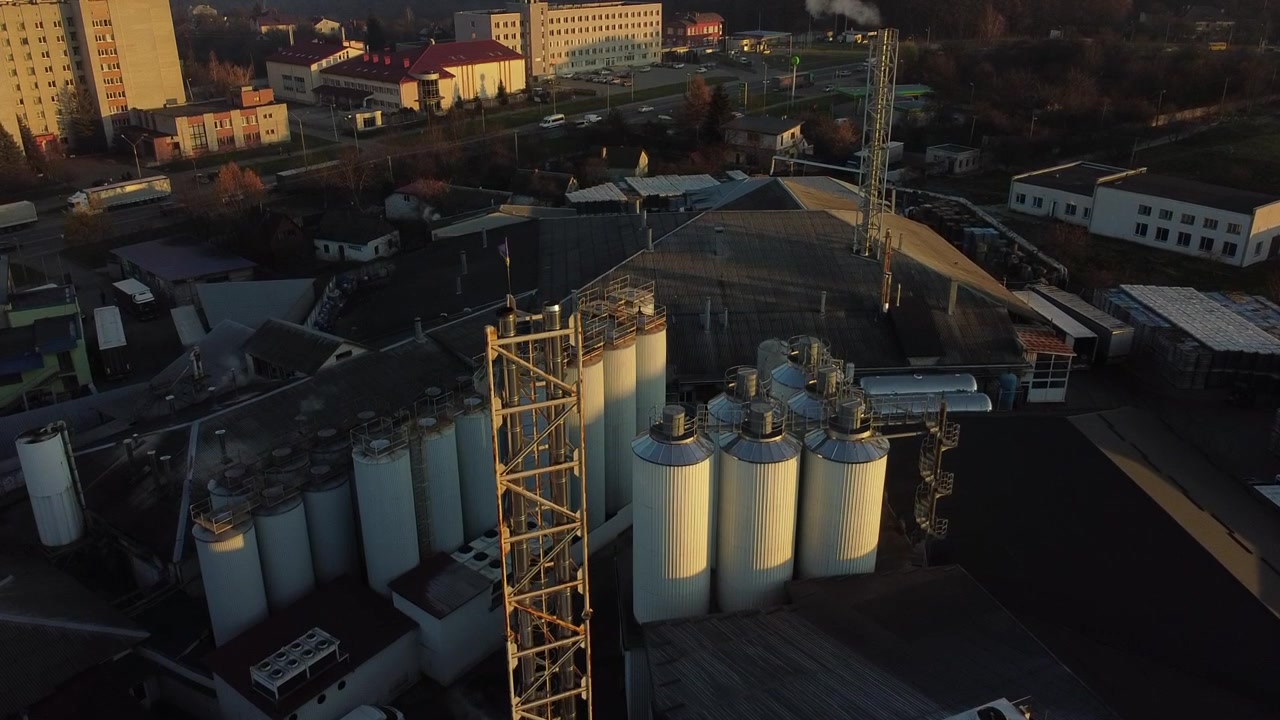 Luftaufnahme einer Drohne, die über eine Bierproduktionsanlage fliegt, mit mehreren Tankreihen.